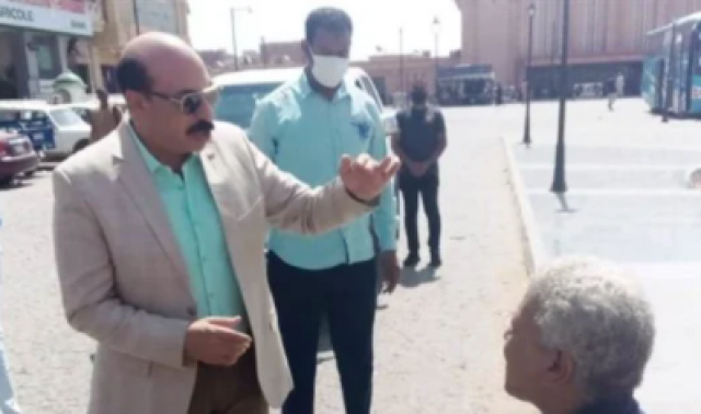 محافظ أسوان مع أحد الشباب من ذوى الإعاقة