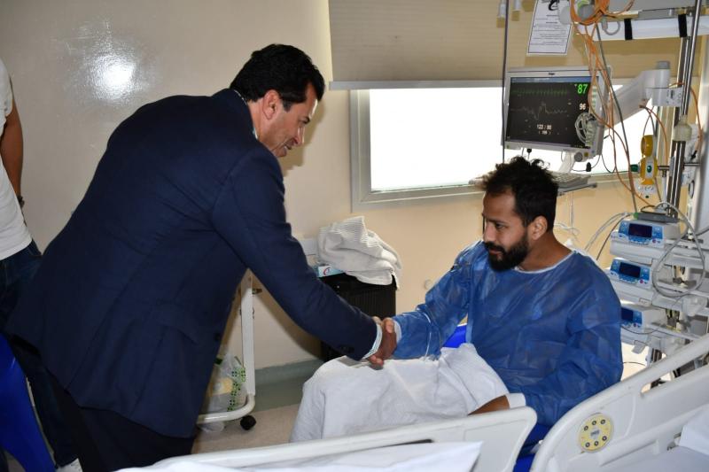 وزير الرياضة يتحدث مع أحمد رفعت خلال زيارته بمستشفى وادى النيل  للاطمئنان على حالته الصحية