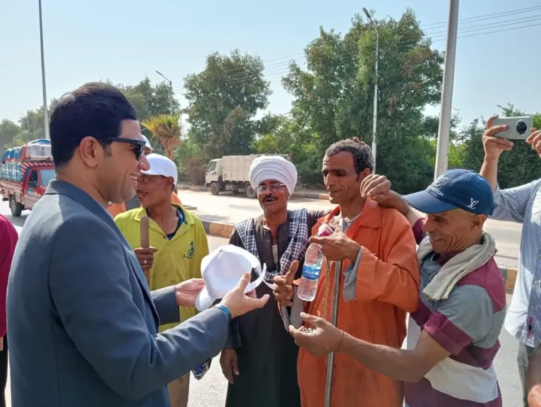 نائب محافظ سوهاج يوزع مواد غذائية وزجاجات مياه وأغطية رأس على عمال النظافة